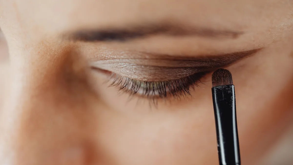 Maquillage des yeux marrons en tons chauds, regard intense et lumineux, tutoriel beauté en gros plan.
